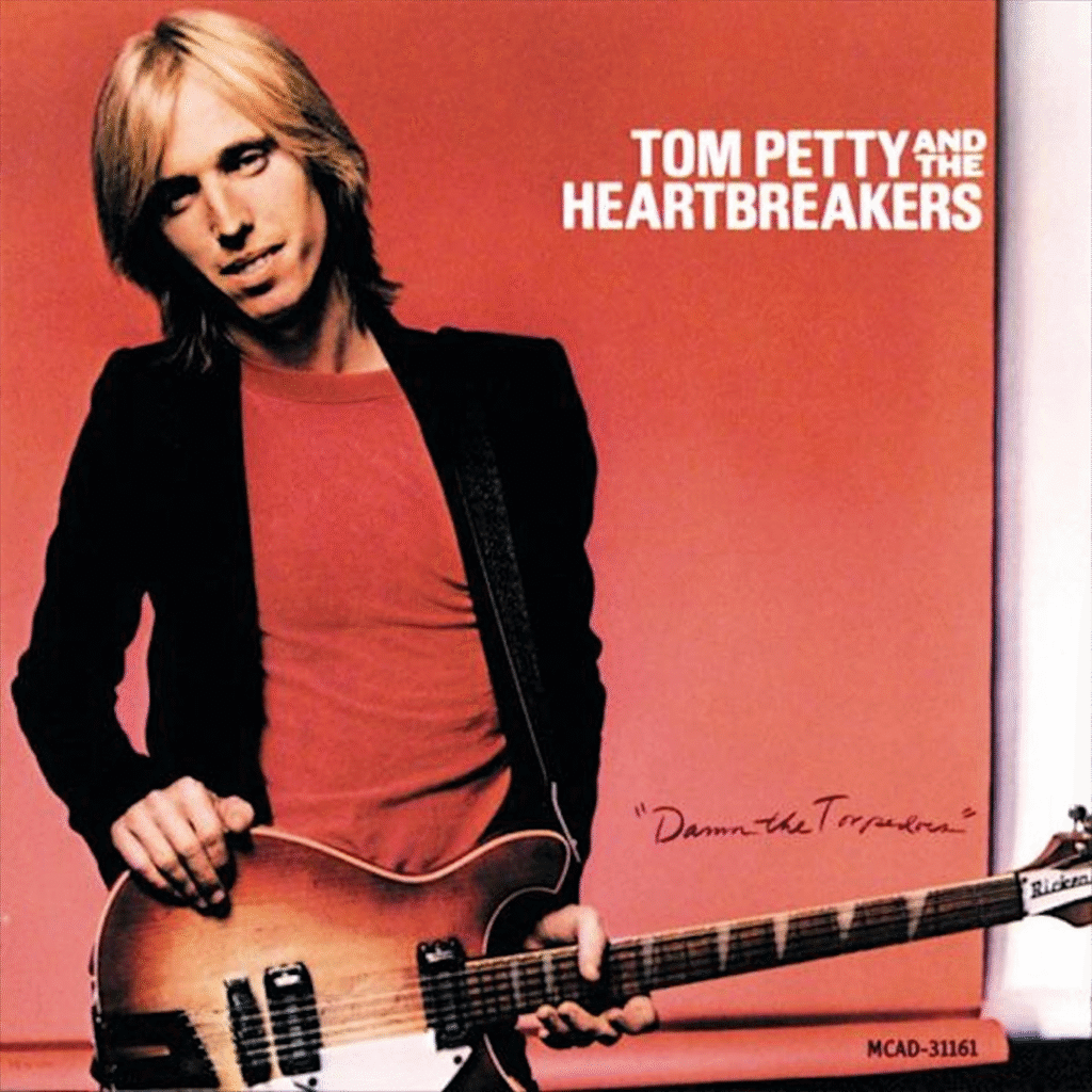 Album cover of "Damn the Torpedoes" by Tom Petty and the Heartbreakers. Features a person with long hair holding a guitar against a red background.