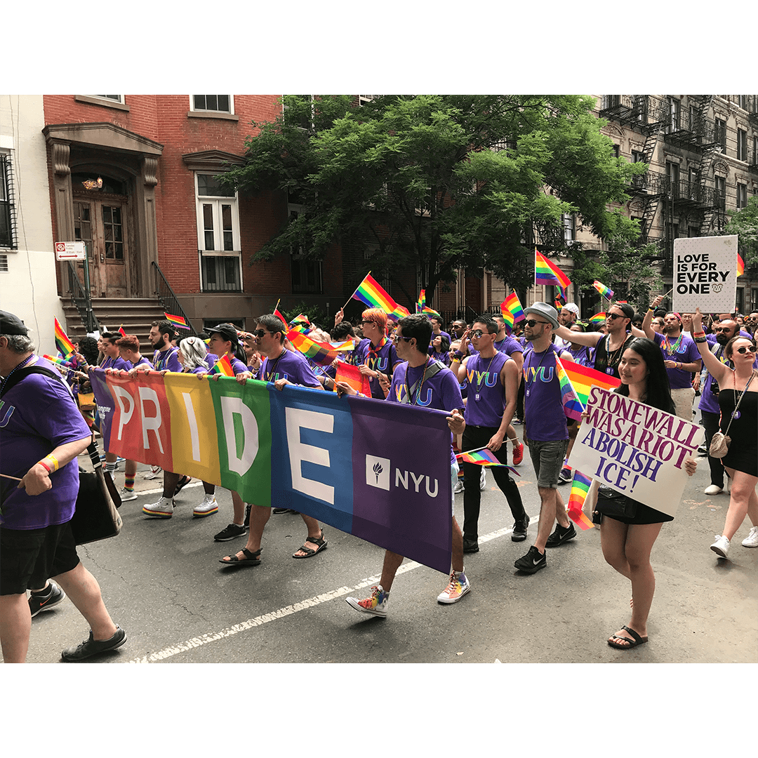 A vibrant Pride parade features individuals in purple shirts holding rainbow flags and a large "PRIDE" banner. Signs advocate for equality and love.