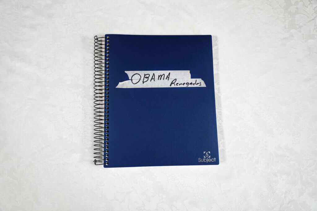 A blue spiral notebook on a white surface. "OBAMA Renegades" is handwritten on tape affixed to the cover. The notebook is labeled "1 Subject."