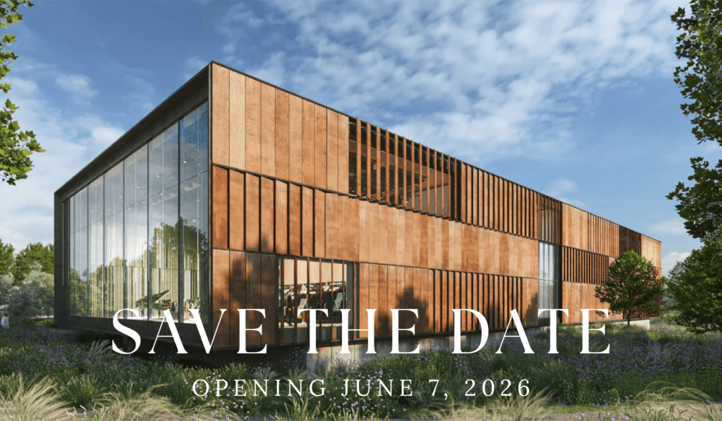 Modern building with wooden panels and large glass windows under a clear blue sky, surrounded by greenery. Text reads "Save the Date, Opening June 7, 2026."